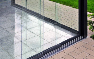 Robuste Schiebetür aus Glas mit nahtloser Bodenschiene
