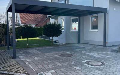 Carport mit Pflasterung und Zugang zum Garten