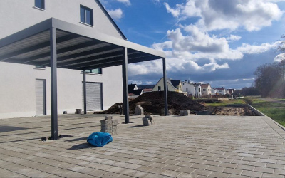 Carport mit Glasdach und parkendes Auto neben dem Haus