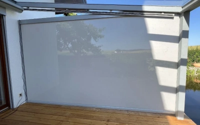 Terrassenmarkise mit seitlichem Glaswindschutz
