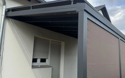 Schlichte Wandmarkise über Sitzbereich im Garten
