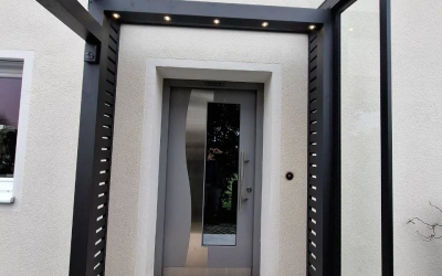 Modernes Glasvordach über der Eingangstür
